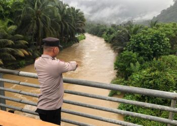 Personil Polsek Lhoong Polres Aceh Besar Monitoring Debit Air Pasca Hujan Deras
